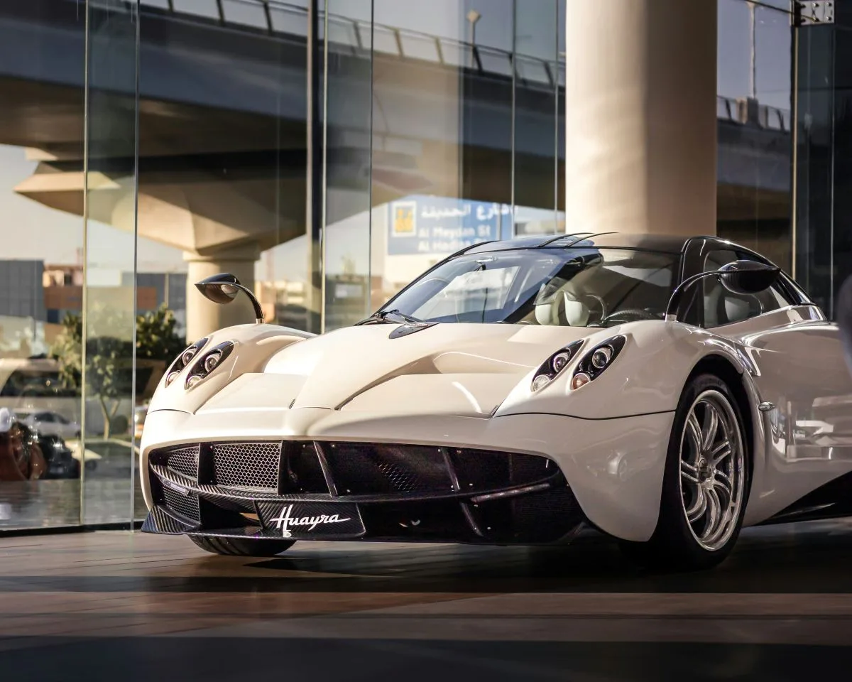 White supercar displayed in a modern showroom.