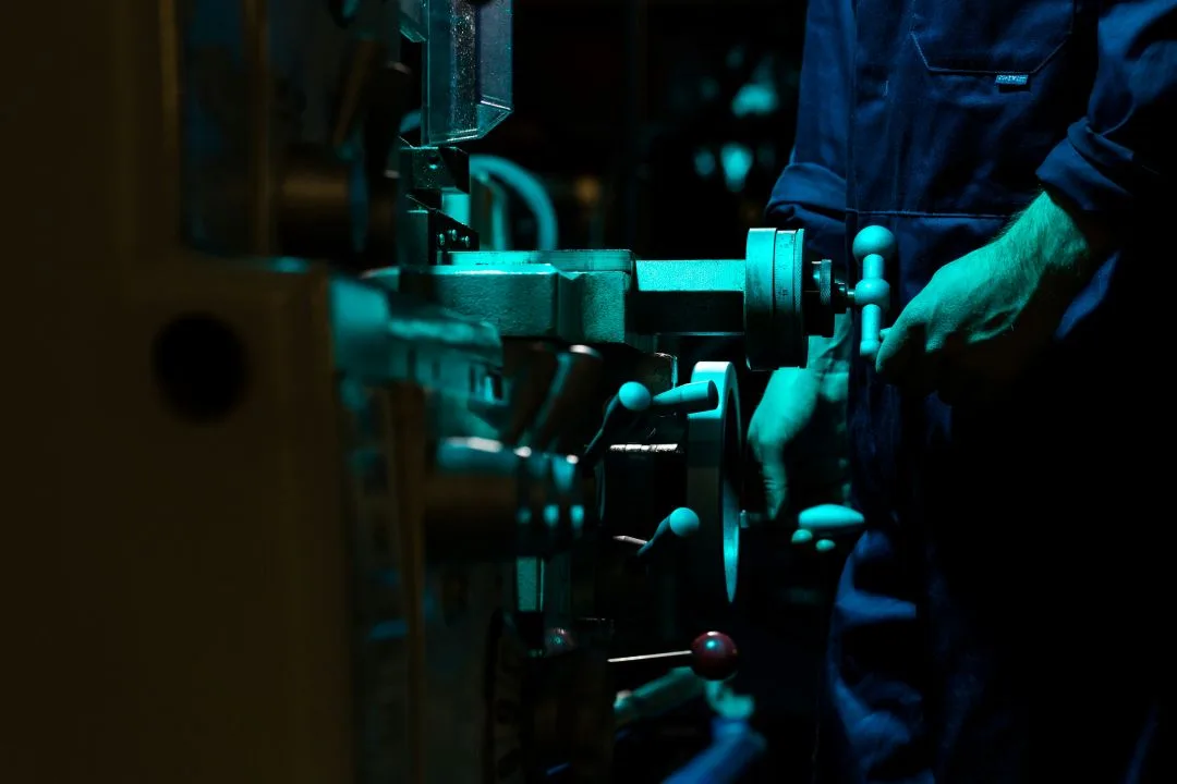 Worker operating an industrial machine in a workshop.