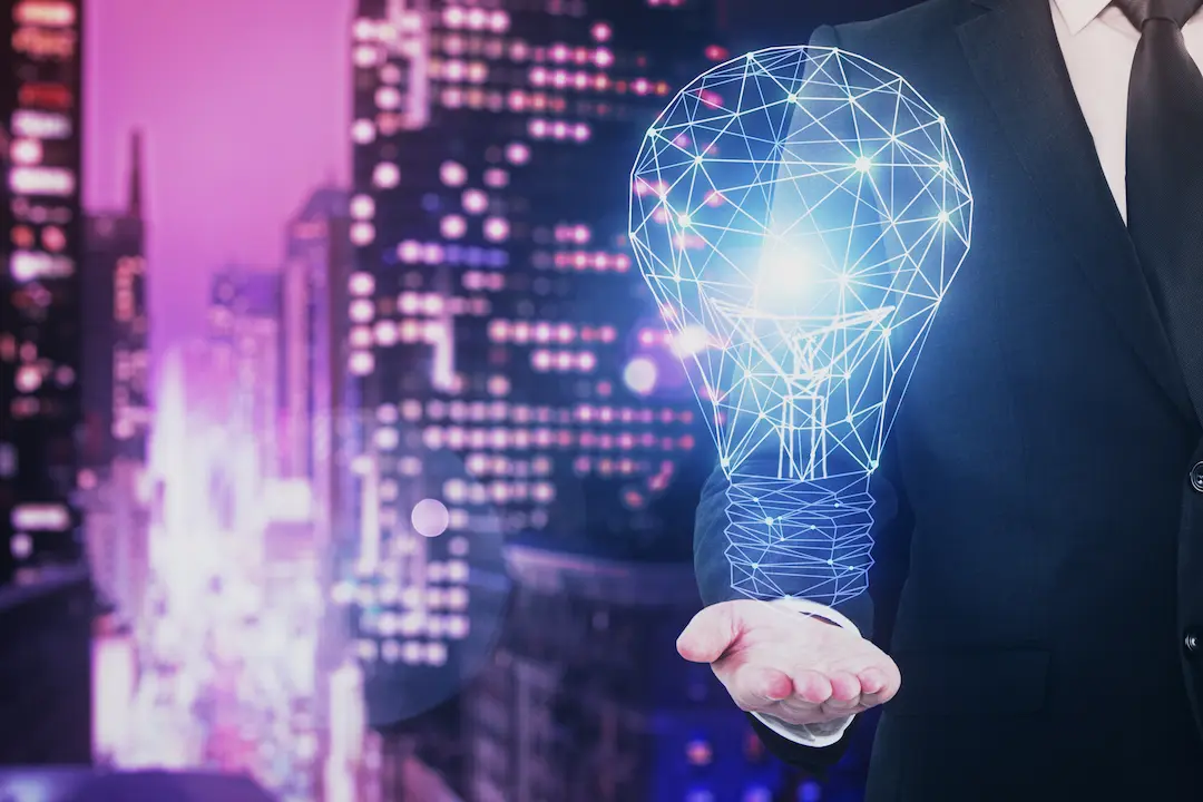 Businessperson holding a digital light bulb symbolizing innovation.