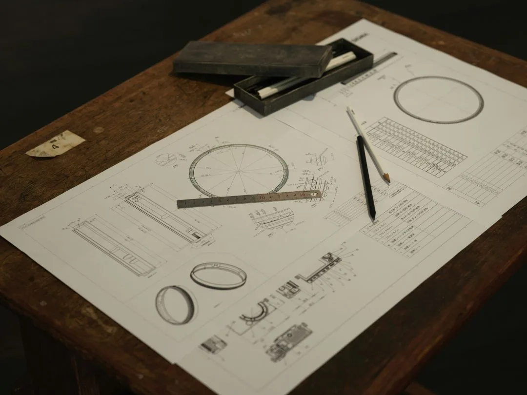 Technical drawings with ruler and pencil on wooden table.