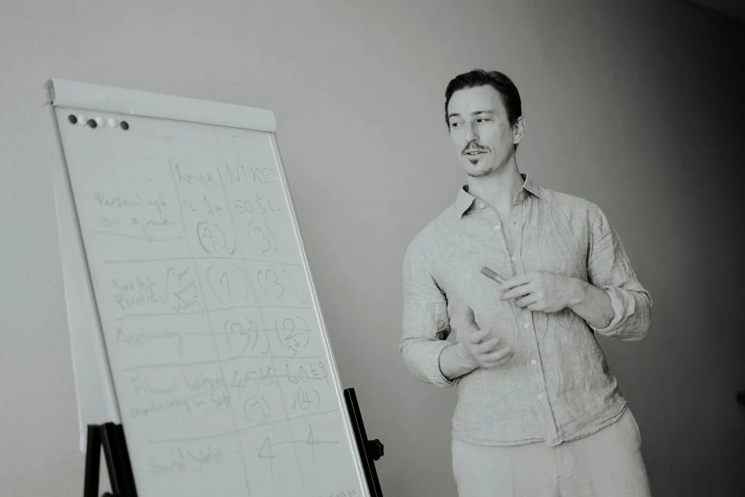 Man presenting at a flip chart with handwritten notes.