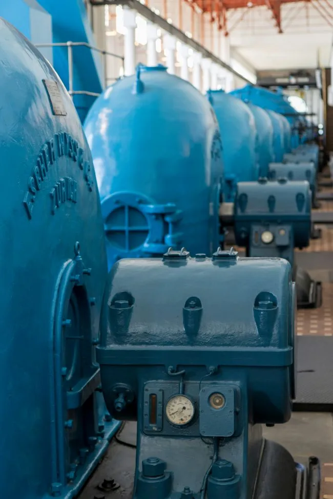 Row of large industrial machines inside a factory hall.