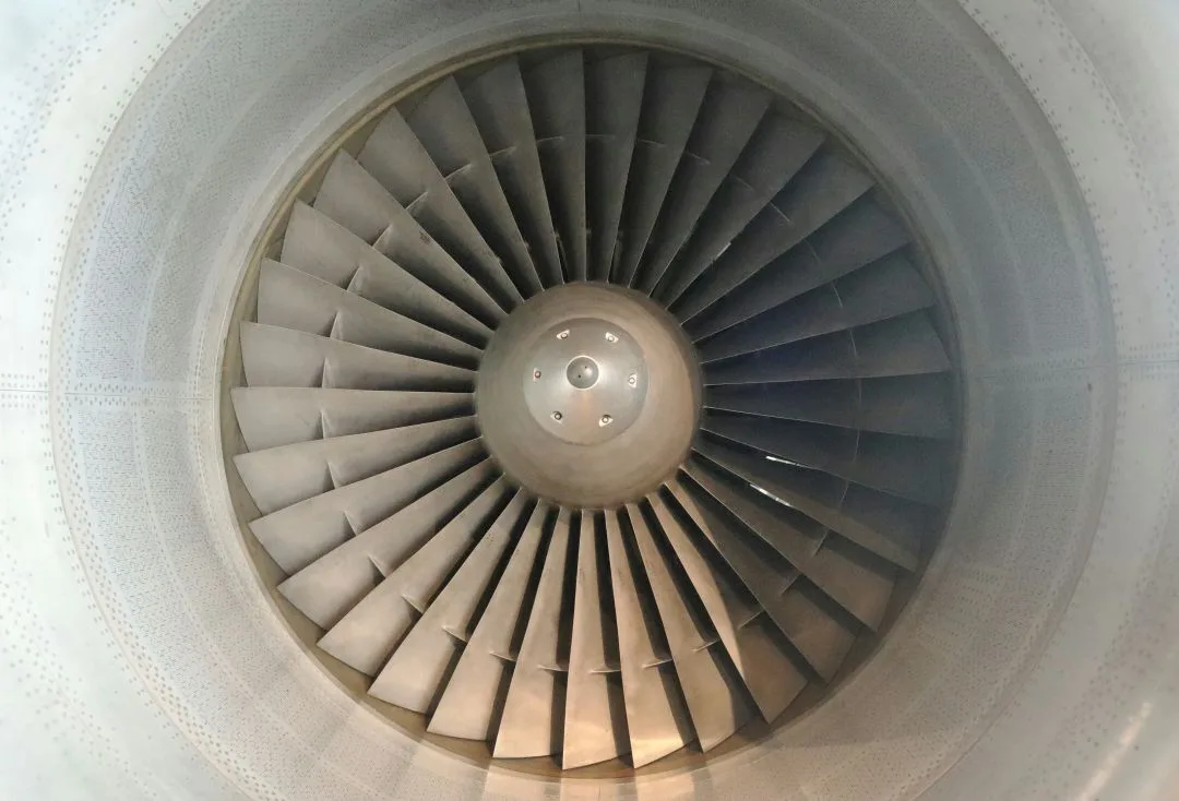 Close-up of an aircraft engine turbine with visible fan blades.
