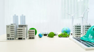 Miniaturmodelle von Gebäuden, Windrädern, Solarpanels und Elektroauto symbolisieren nachhaltige Stadtentwicklung