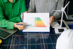 Berater erläutern Energieeffizienzklasse anhand einer Skala von A bis G mit Windrad-Modell
