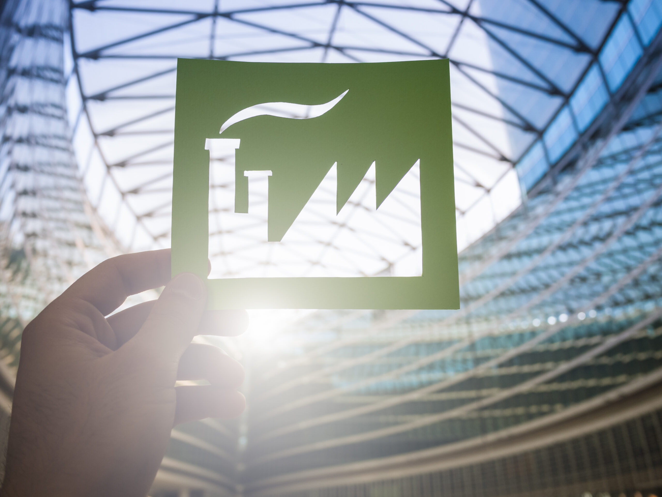 Ausgeschnittenes Fabriksymbol mit Diagramm symbolisiert nachhaltige Industrieproduktion