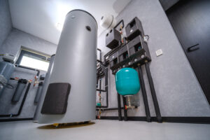 Hot water tank and heating system manifold with plumbing in a basement utility room